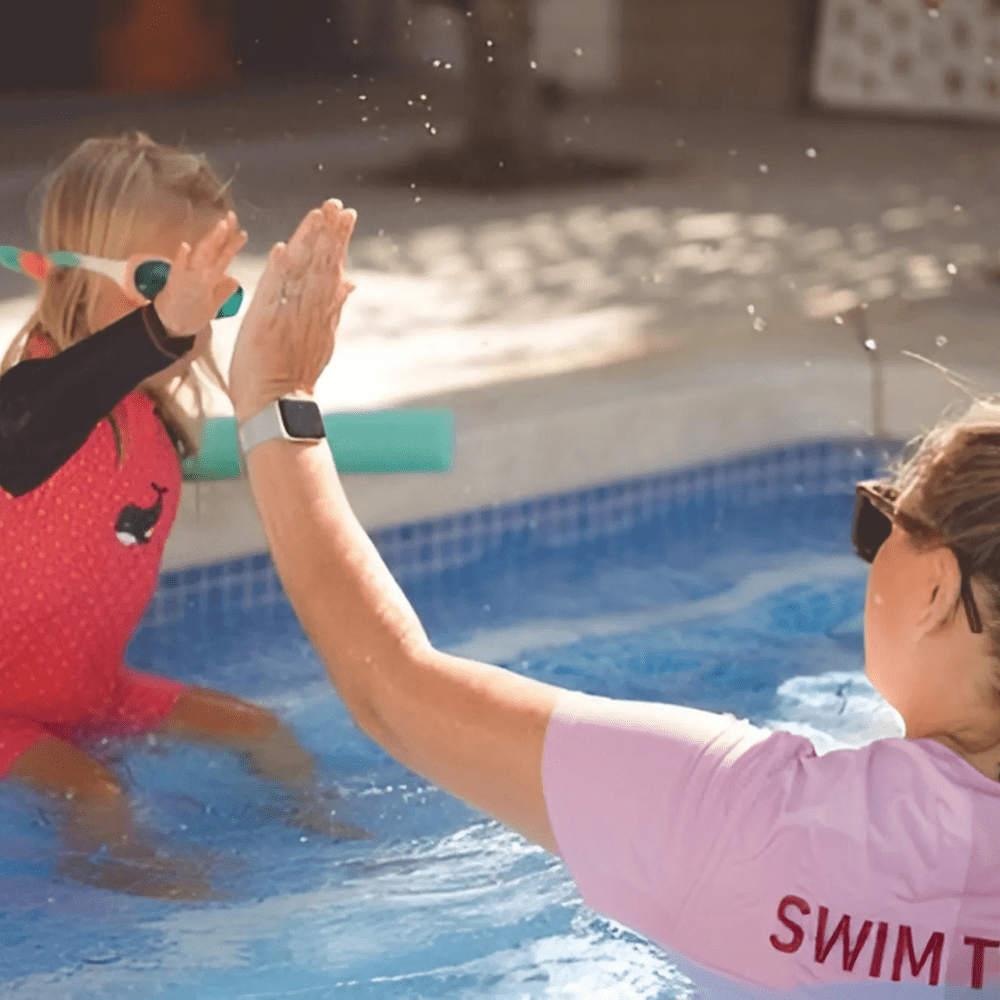 kidtastic rebecka highfiving a toddler in the pool