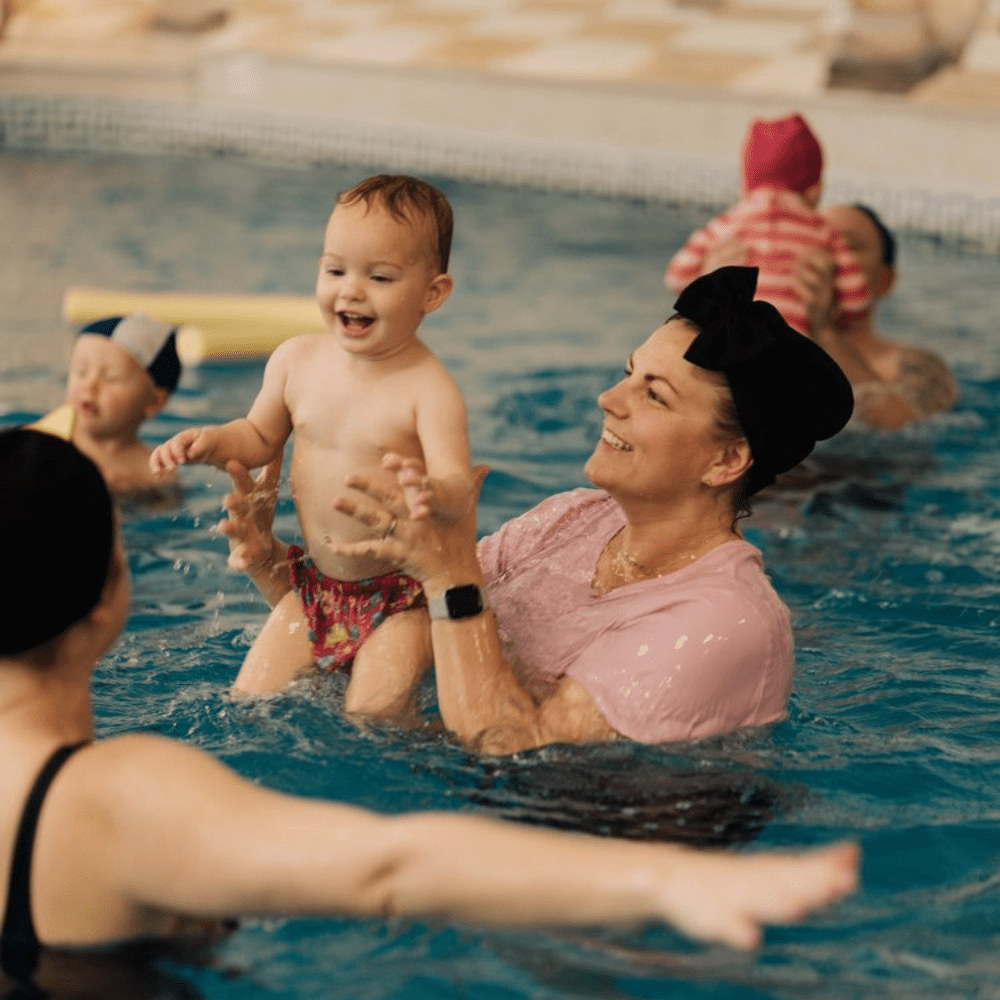 kidtastic rebecka holding a baby in pool