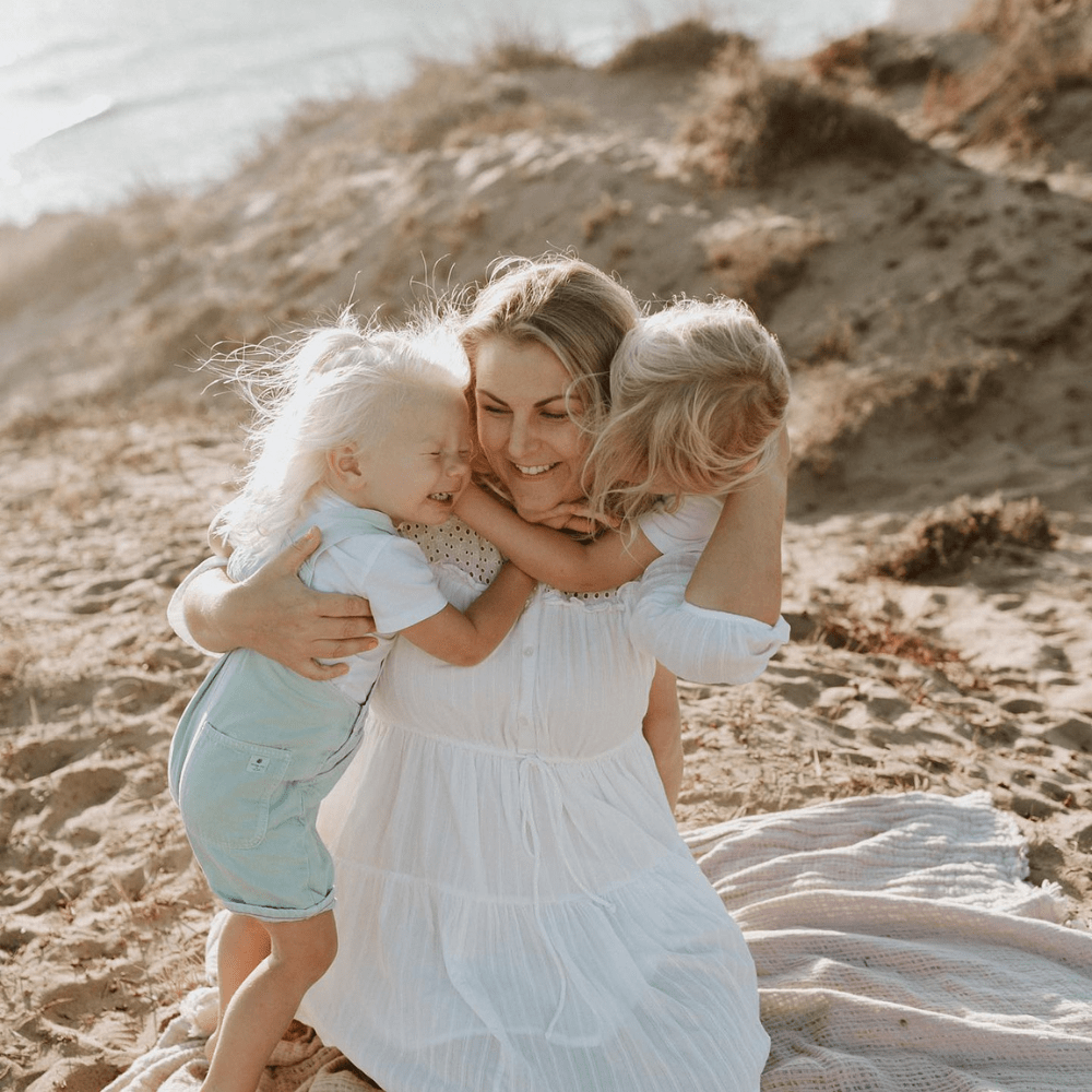 kidtastic rebecka hugging her children on a beach